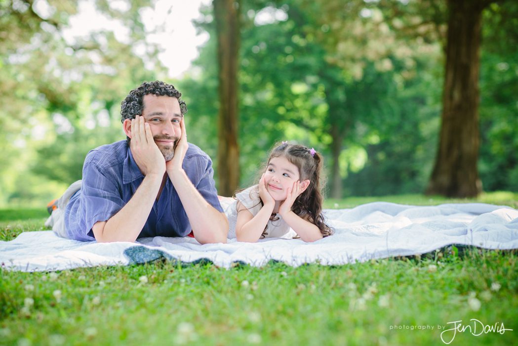 Dad and daughter on a blanket in a park in summer