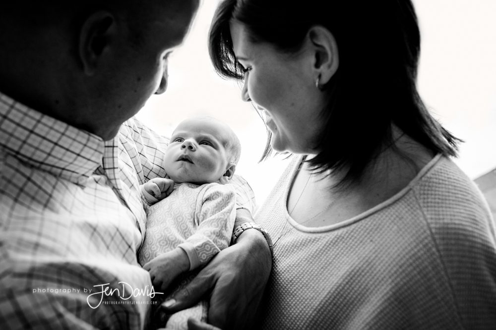 Black and White image of mom and dad holding baby