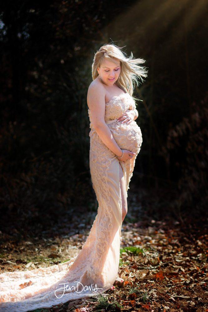 Pregnant woman in the woods draped in fabric