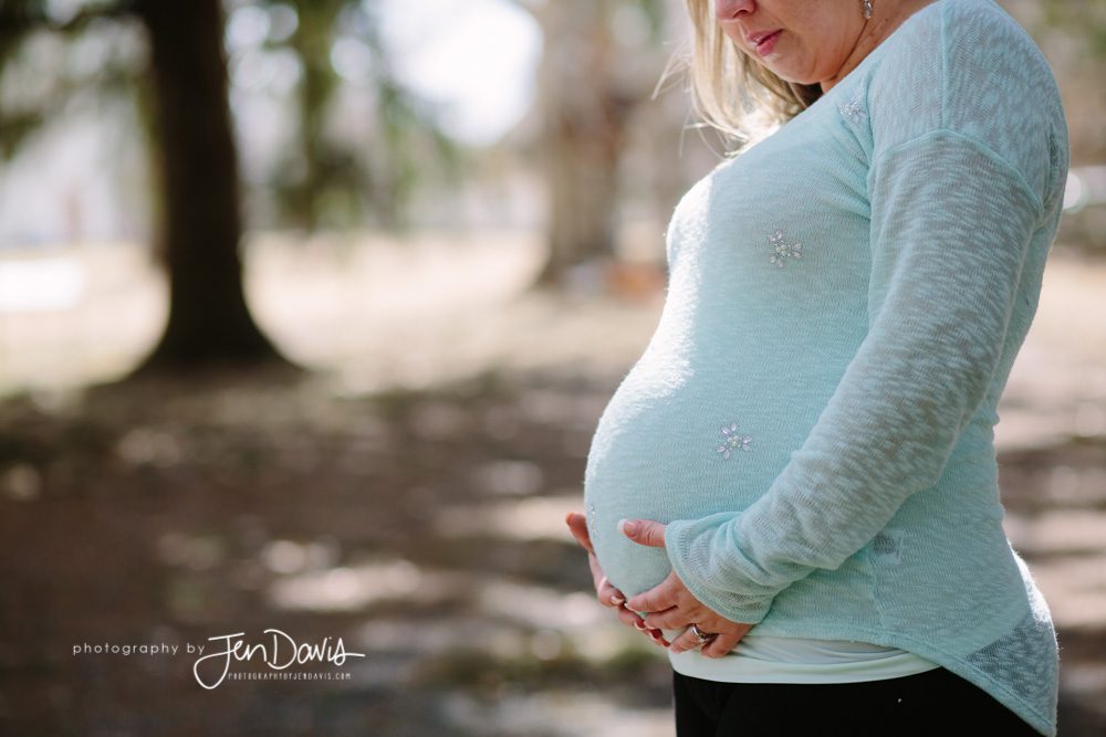 Pregnant woman wearing blue in the woods 