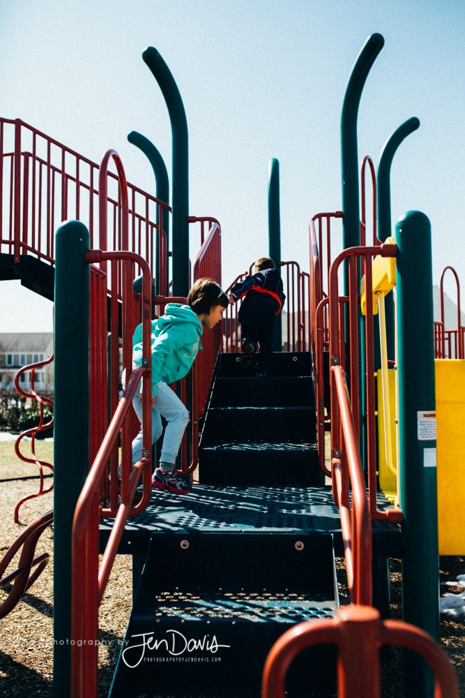 brother and sister climbing playground equipment