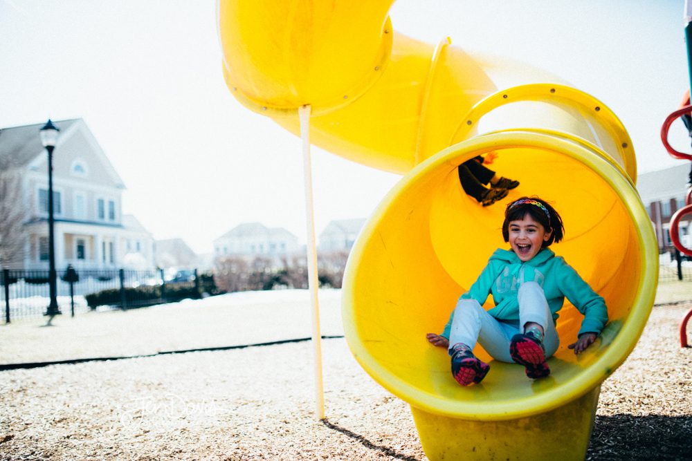 Little girl sliding down yellow slide