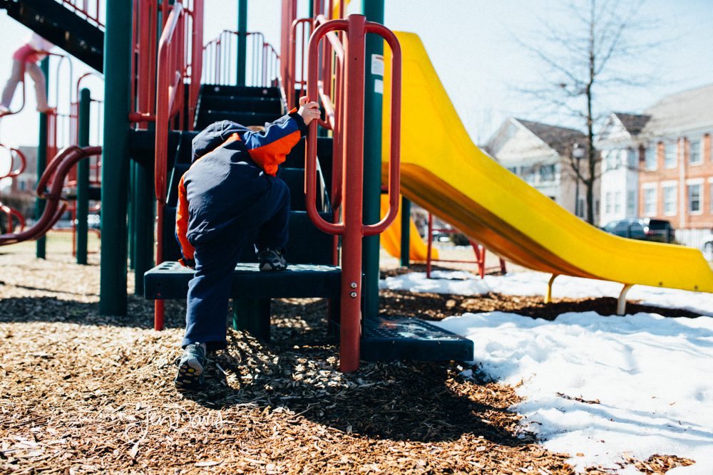 Boy climbing on playground equipment