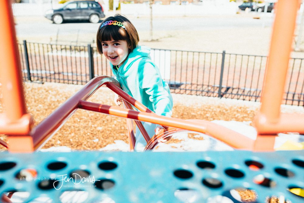 Little girl climbing on playground equipment