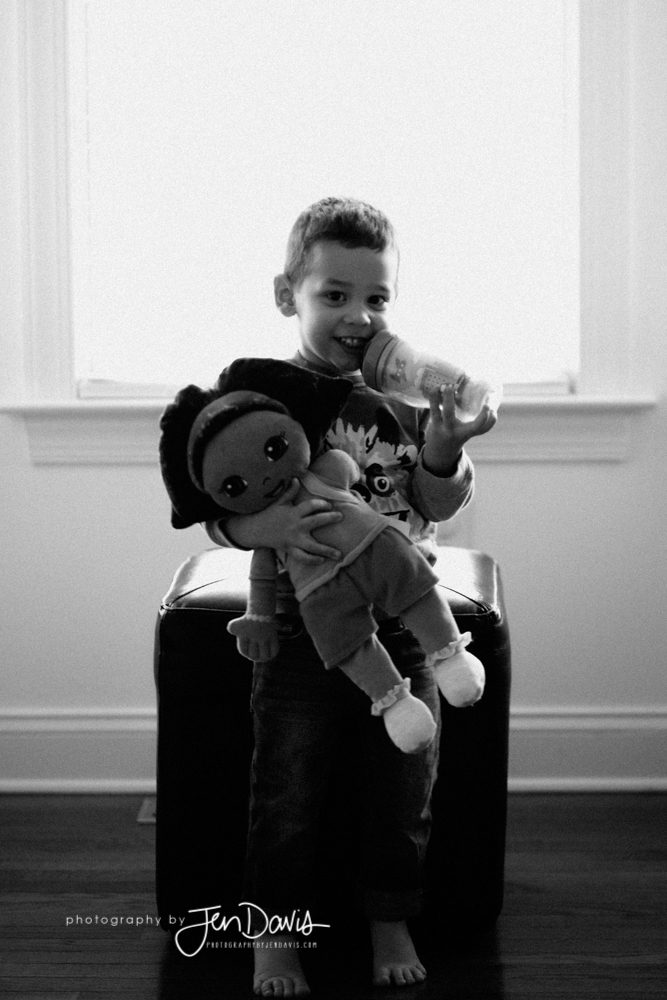 Little boy drinking Milk with a stuffed Dora Doll