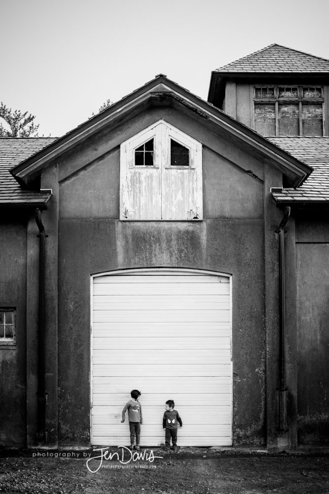 two kids in front of a door in black and white