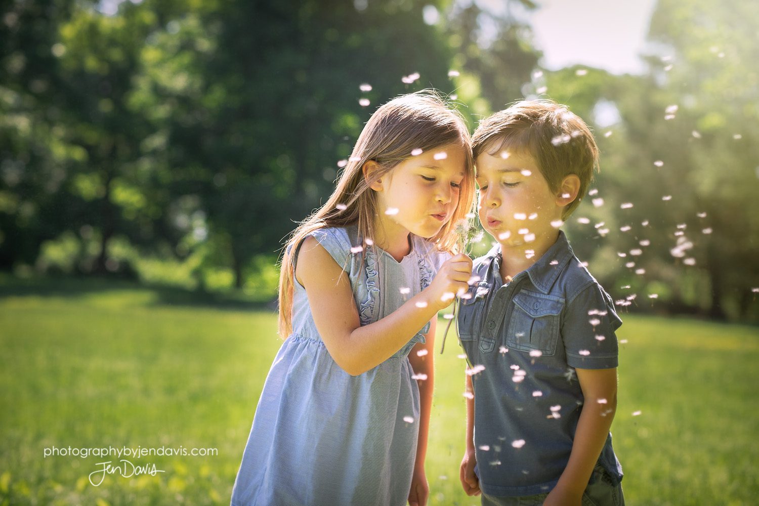 brother and sister blowing dandelion 