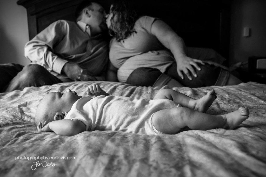 black and white of newborn on the bed with mom and dad