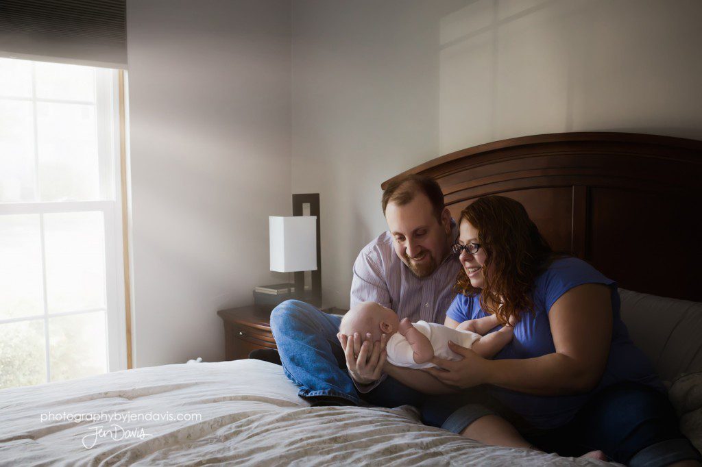 newborn on the bed with mom and dad