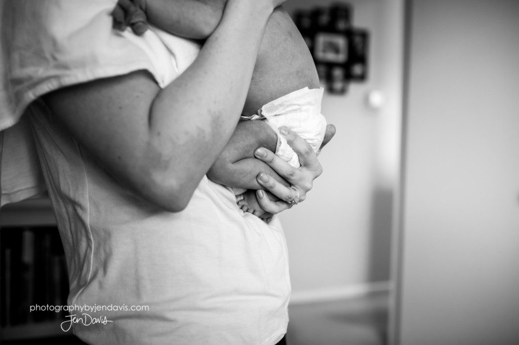 black and white of mom holding a baby's legs and feet