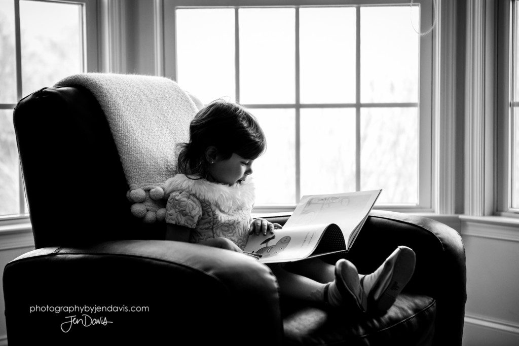 black and white image of a girl reading a book
