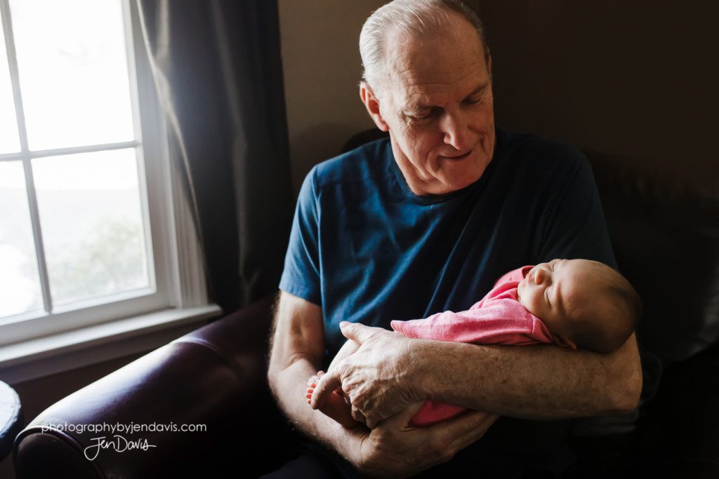 grandfather and baby sitting by a window
