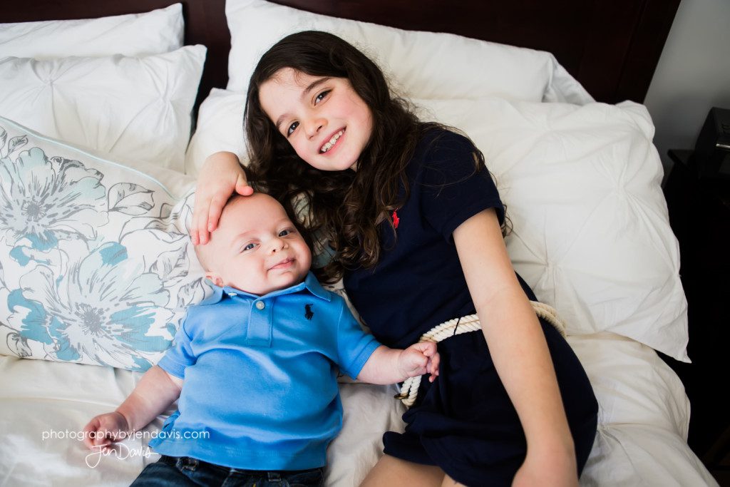girl and baby smiling on bed