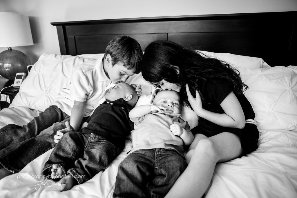 black and white of brothers and sisters on bed