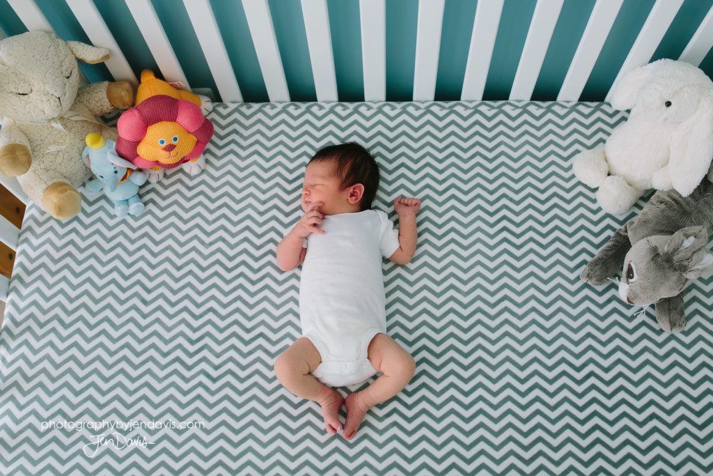 baby in chevron sheets in crib