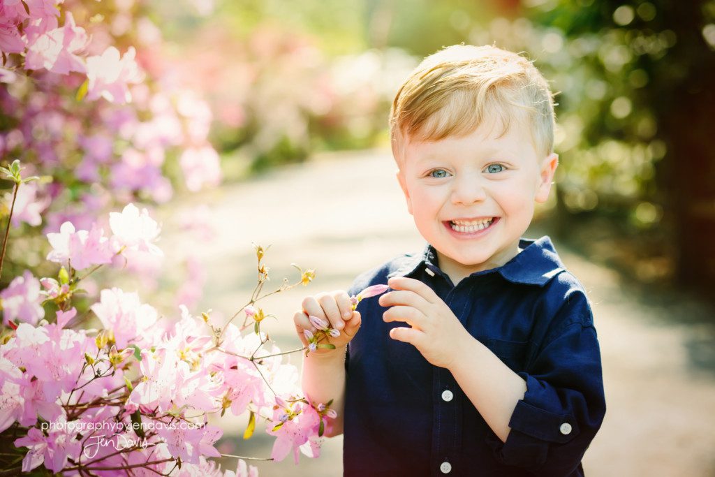 little boy smelling flowers
