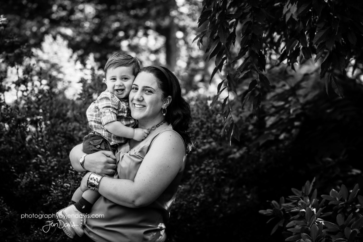 black and white of mom holding son in the garden