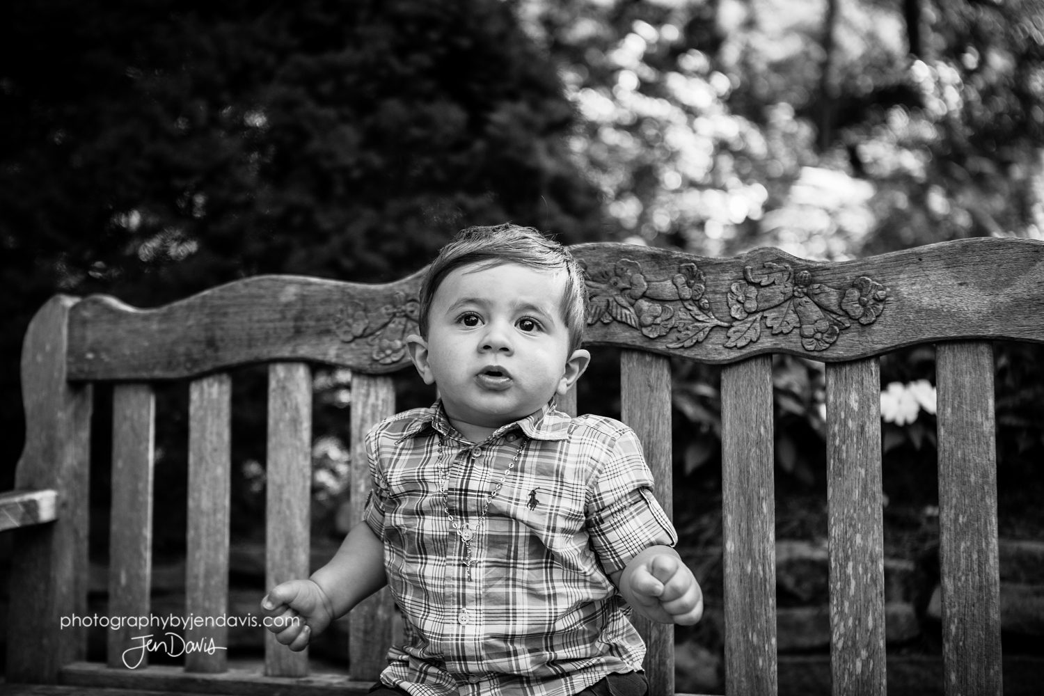 1 year old boy sitting on bench in black and white