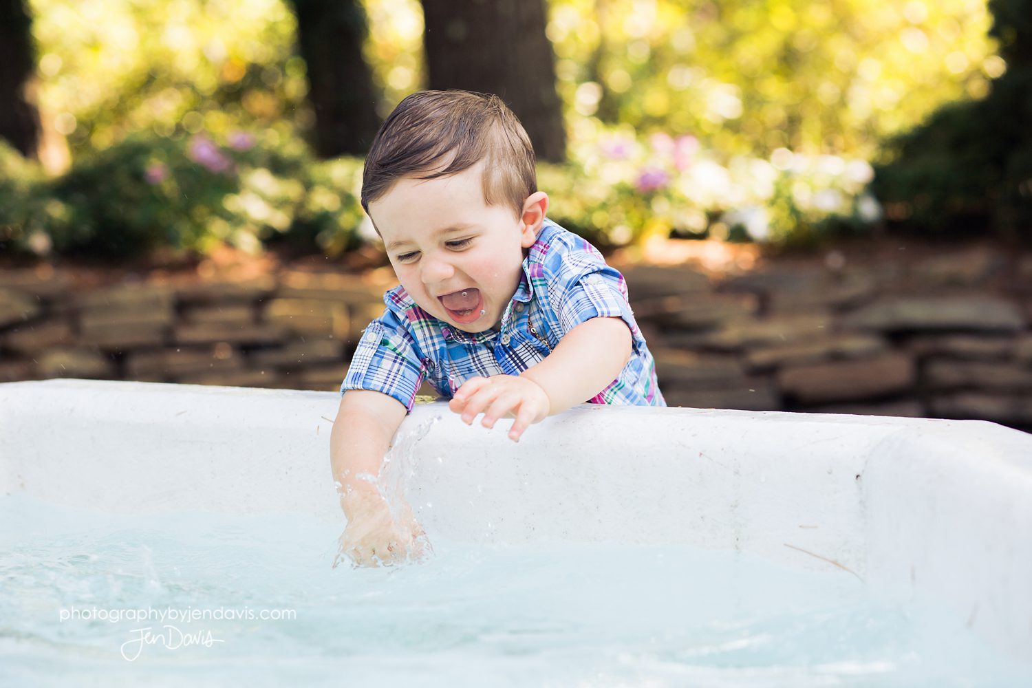 1 year old splashing in the fountain