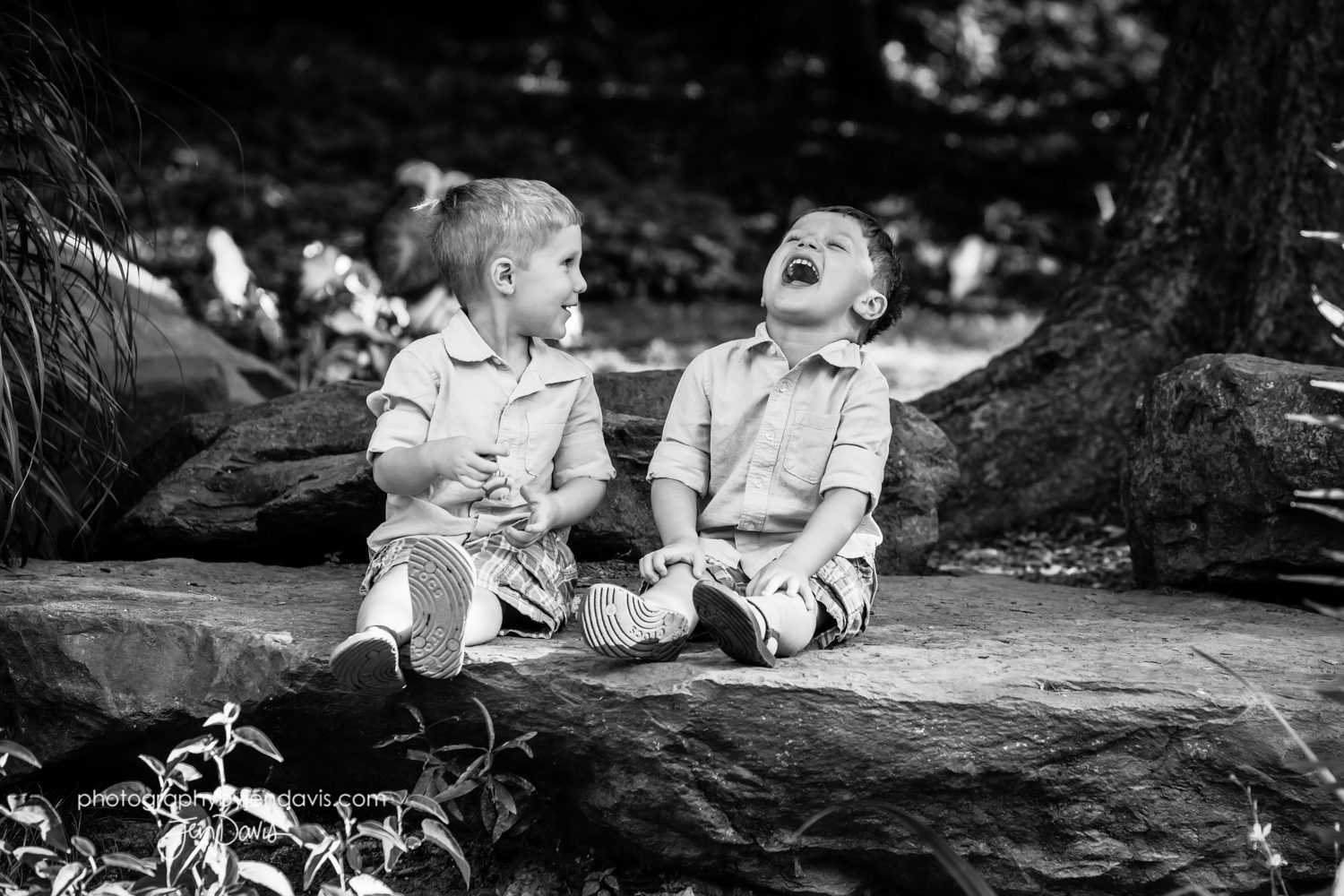 twin boys laughing in black and white