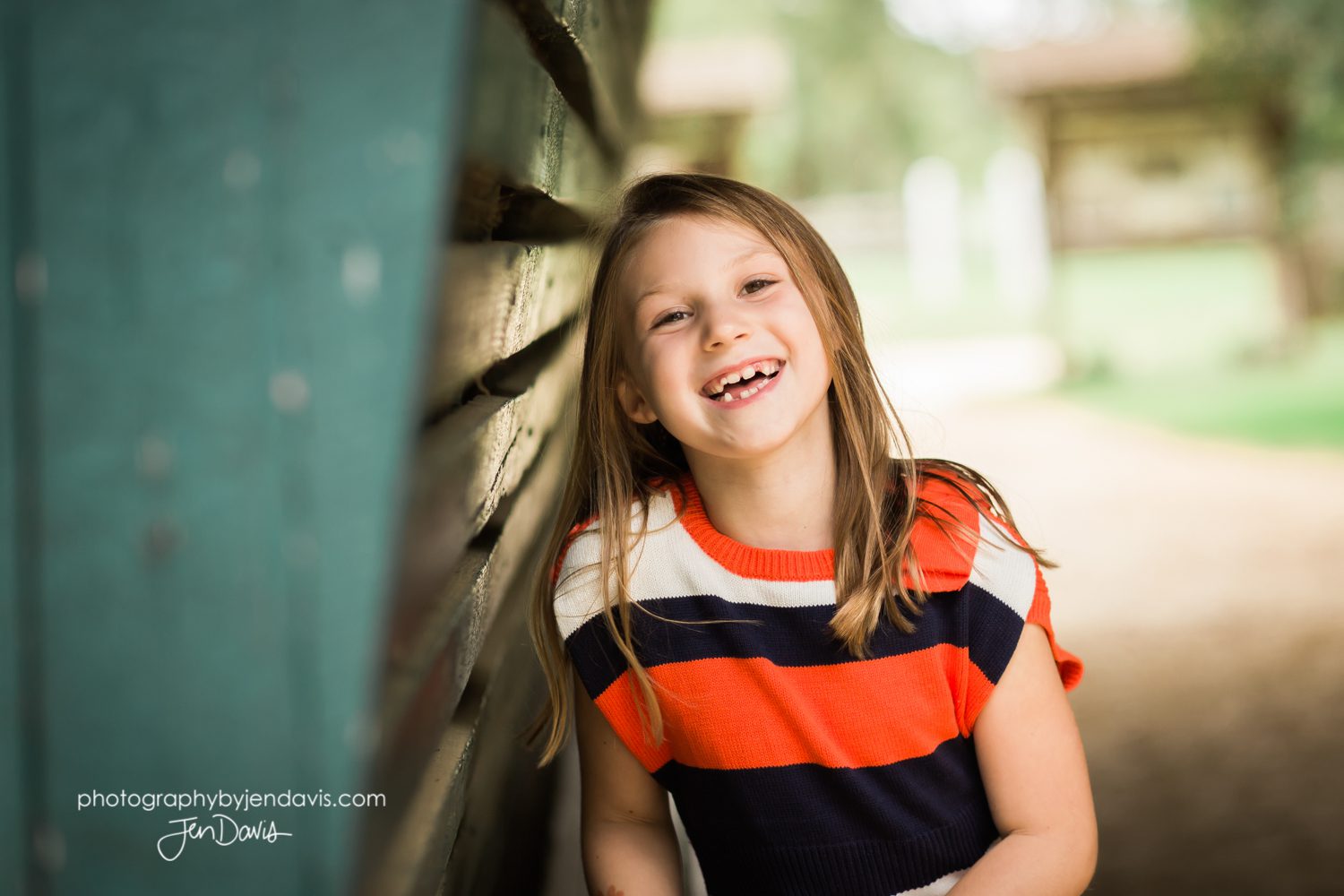 7 year old girl laughing under a bridge