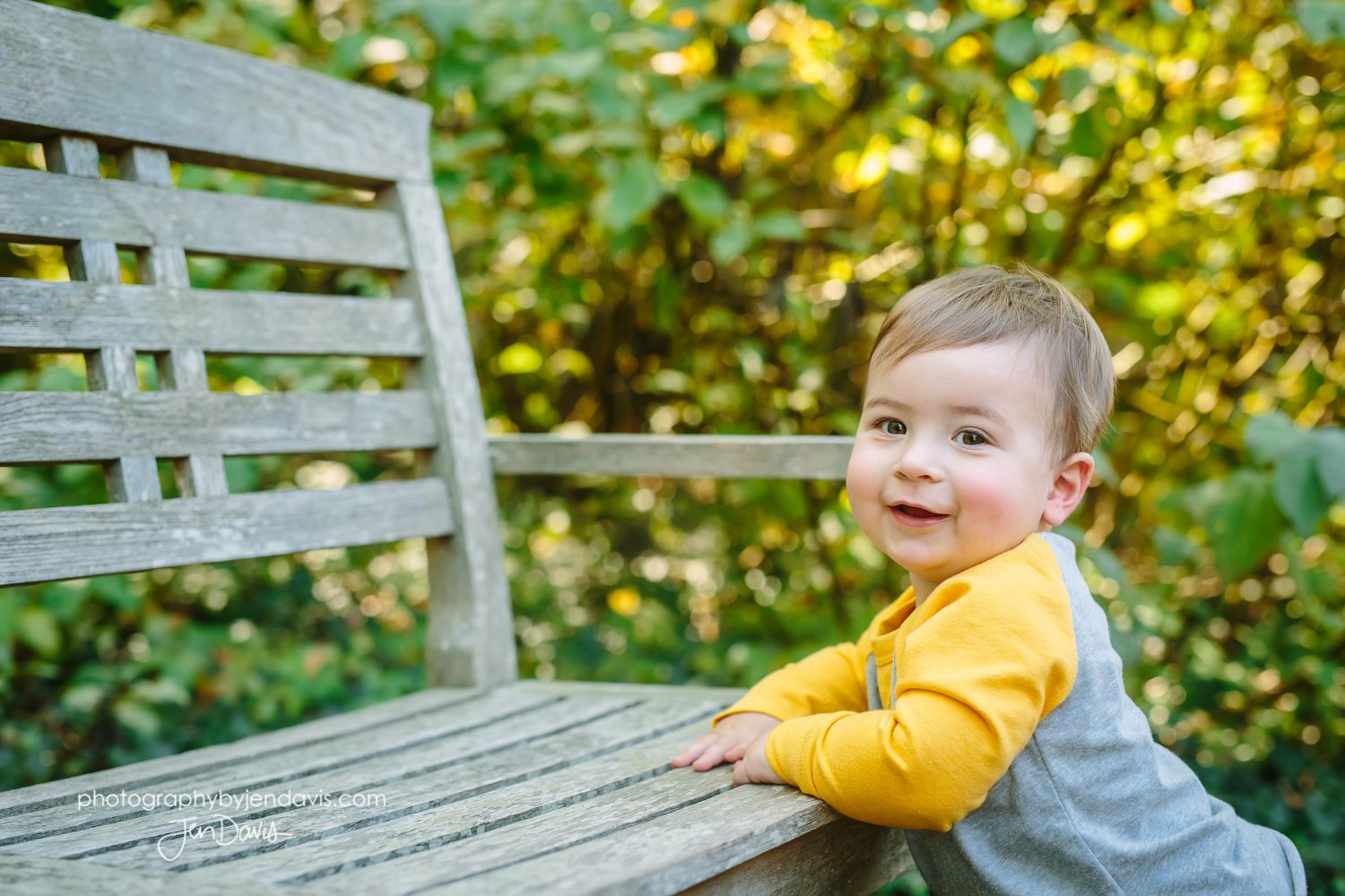 1 year old boy holding onto bench
