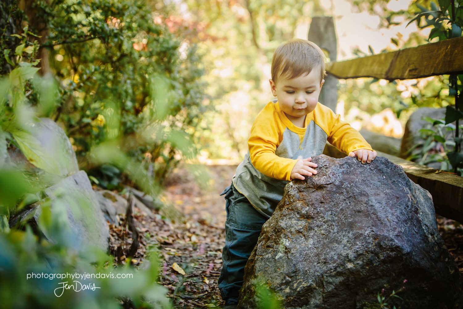 1 year old boy holding onto rock