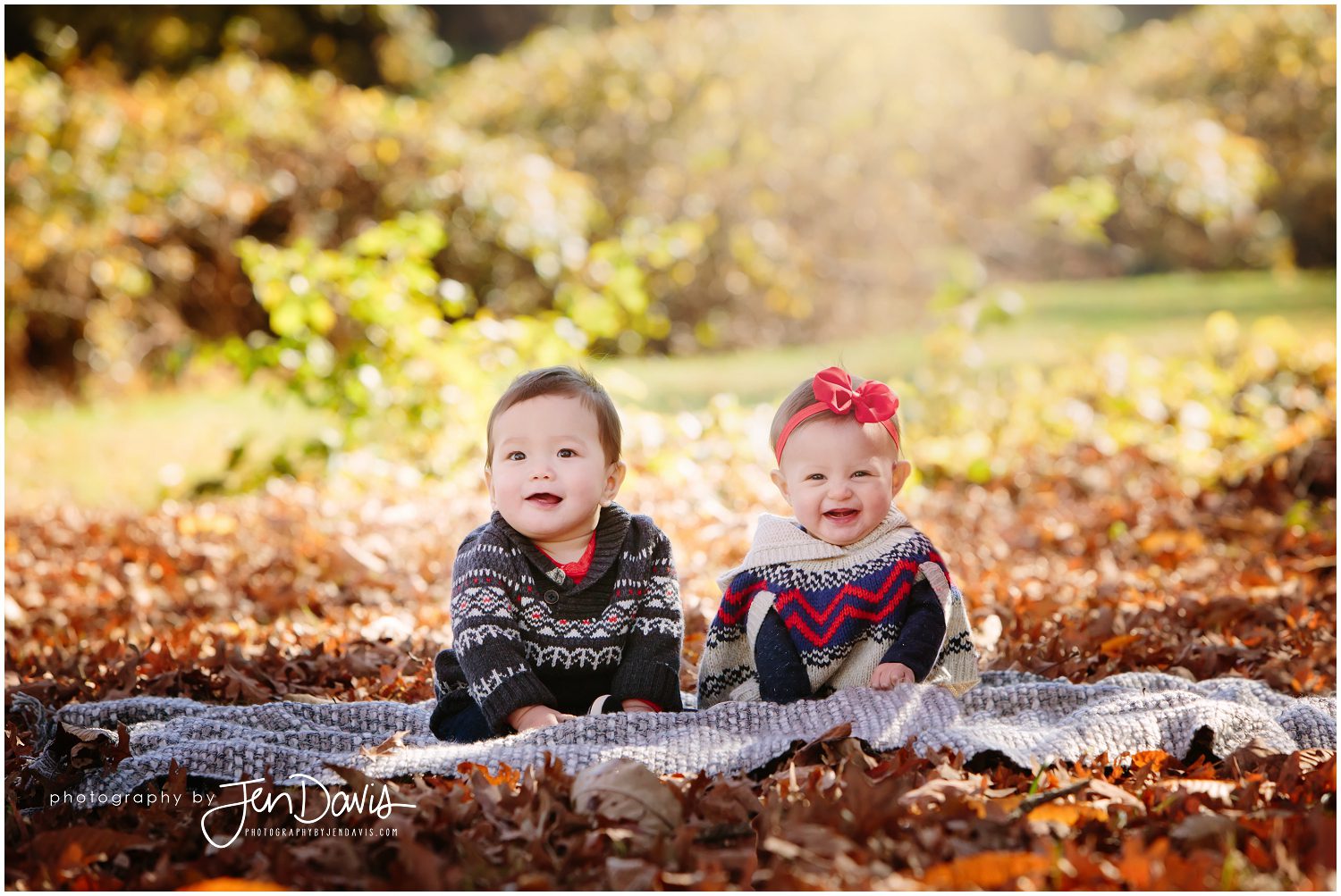 7 month old twins sitting on a blanket in fall