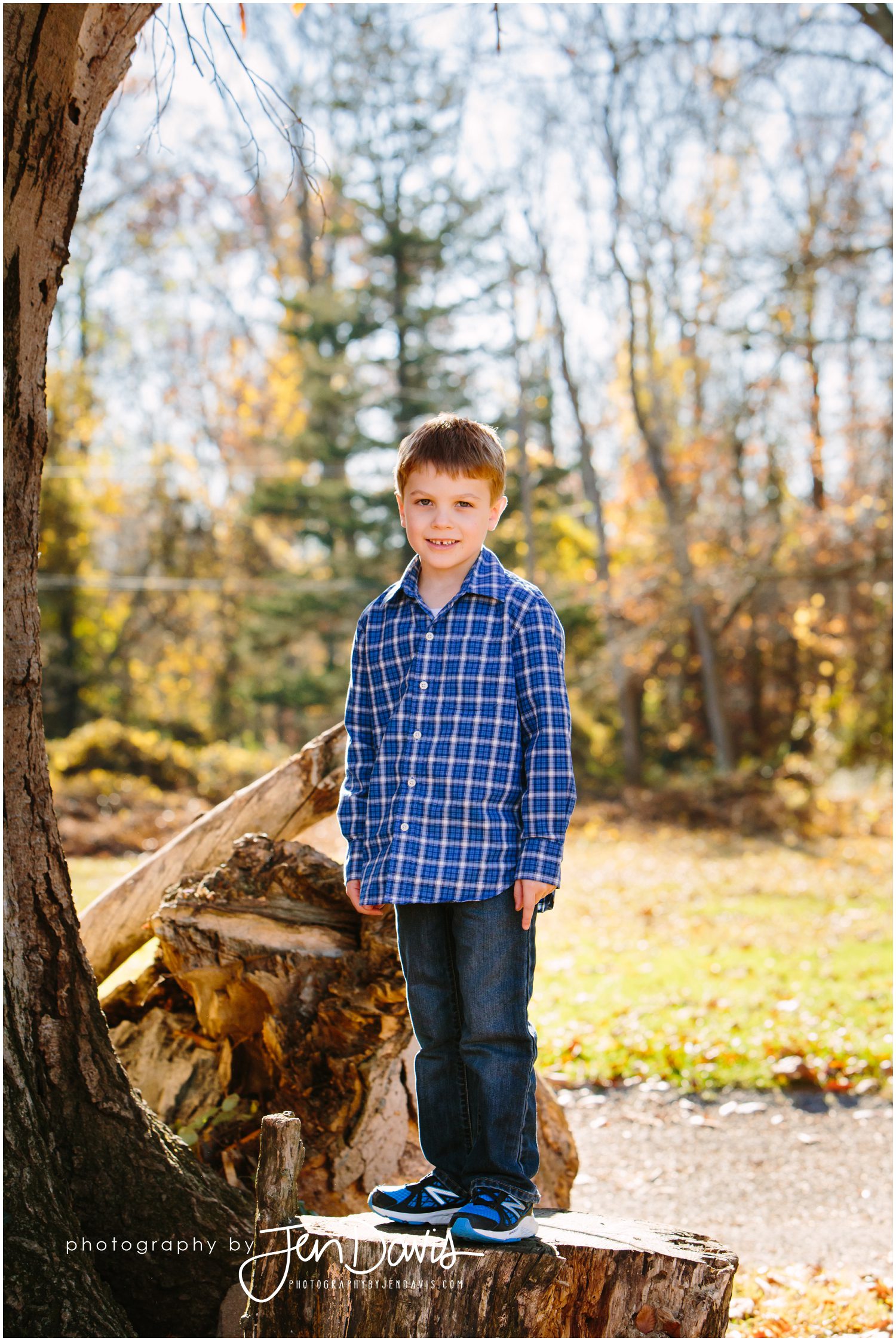 boy on log in woods