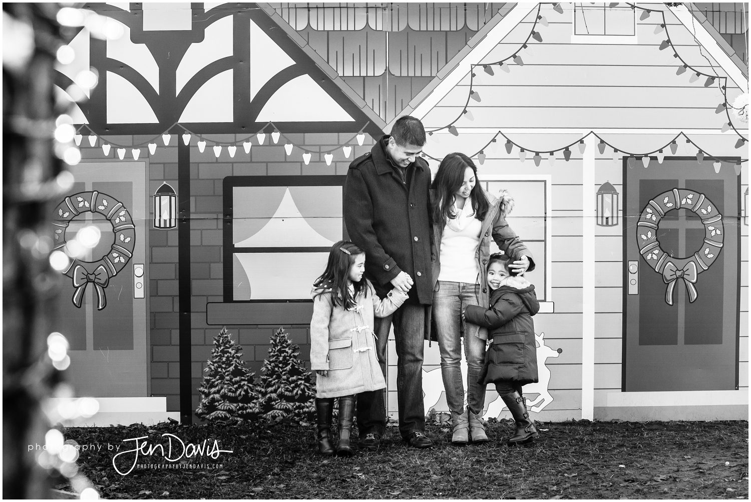 black and white of family standing near christmas village