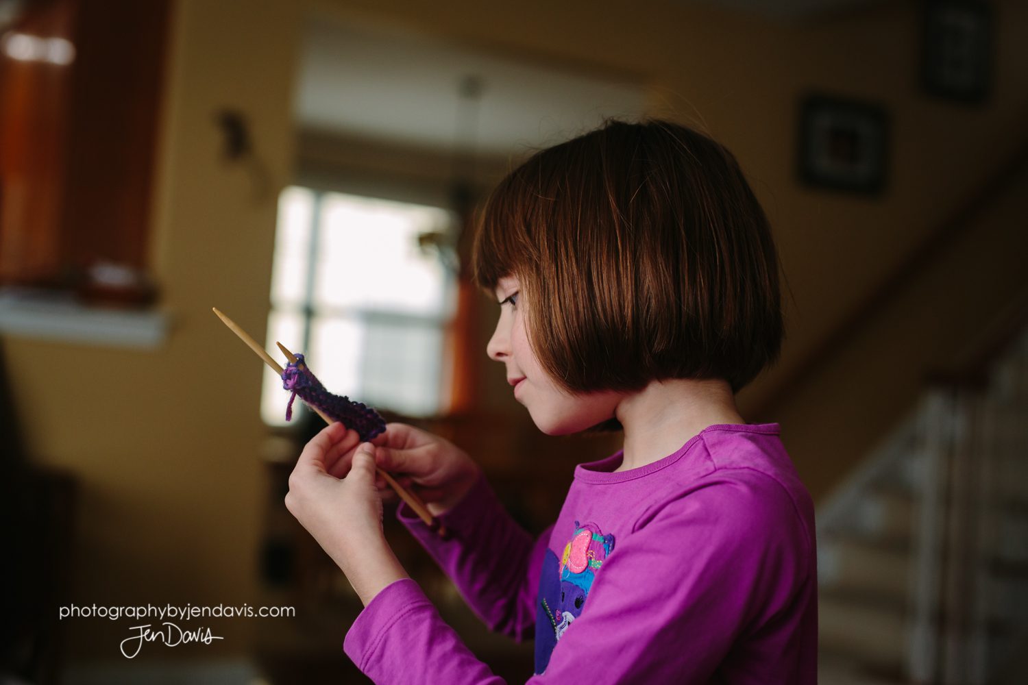 7 year old girl knitting indoors