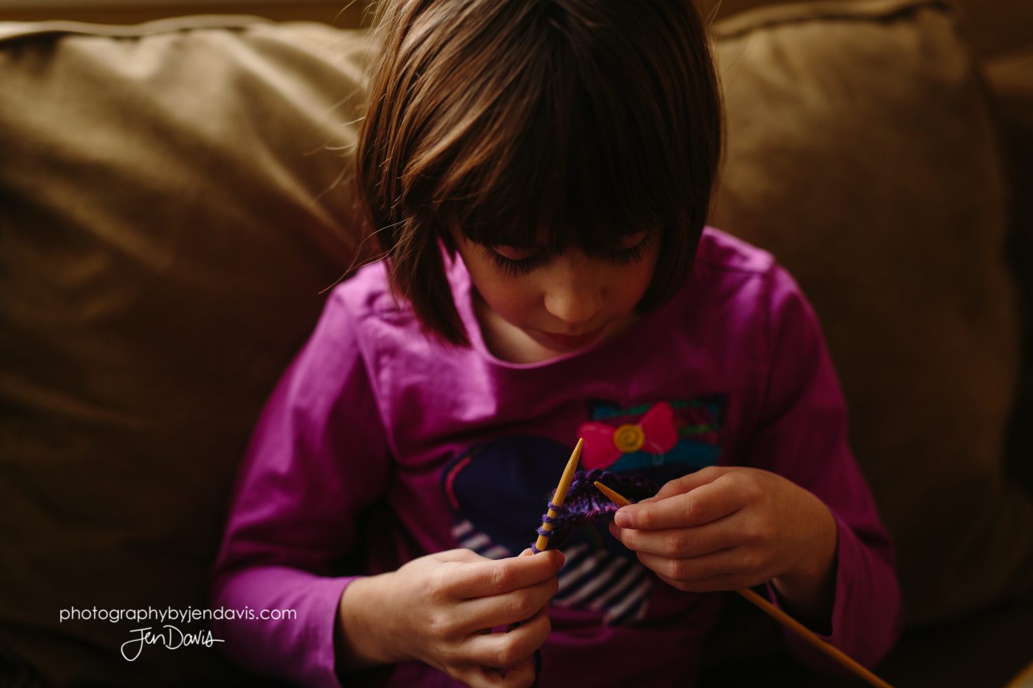 7 year old girl knitting indoors