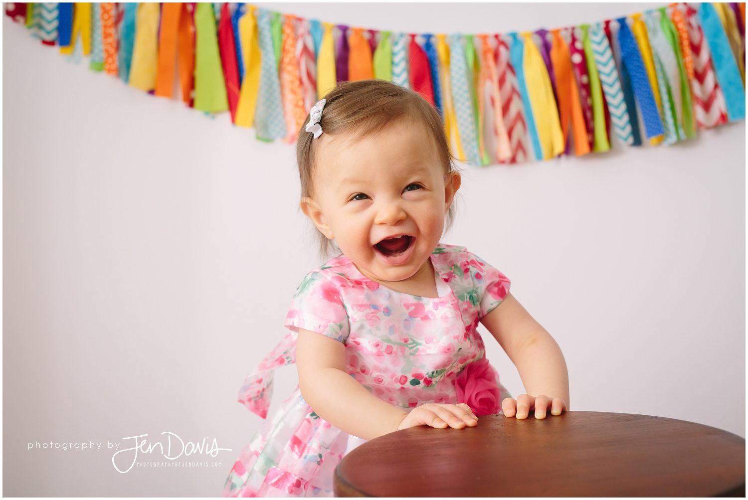 1 year old girl laughing on stool