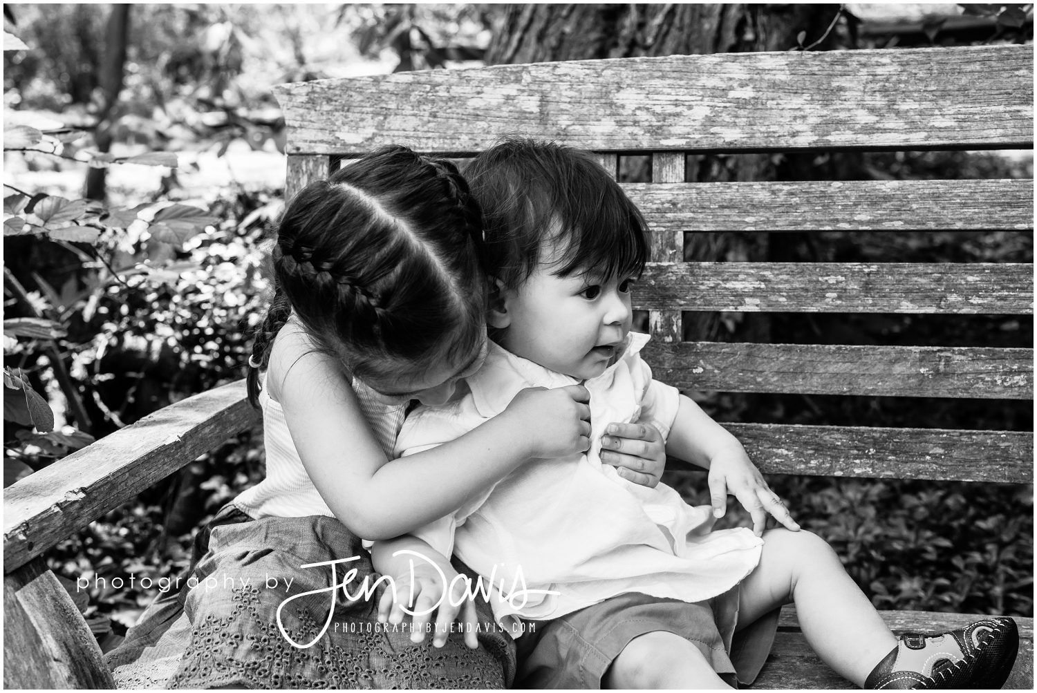 siblings hugging on bench