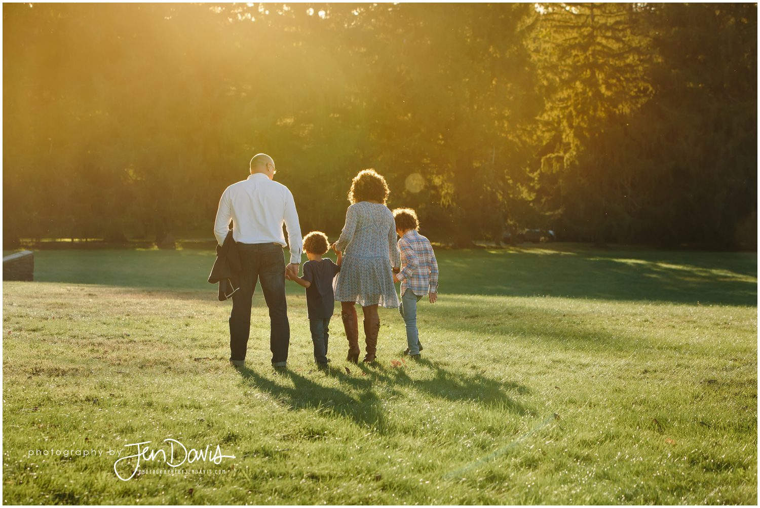 family of 4 walking into the sunset in a park